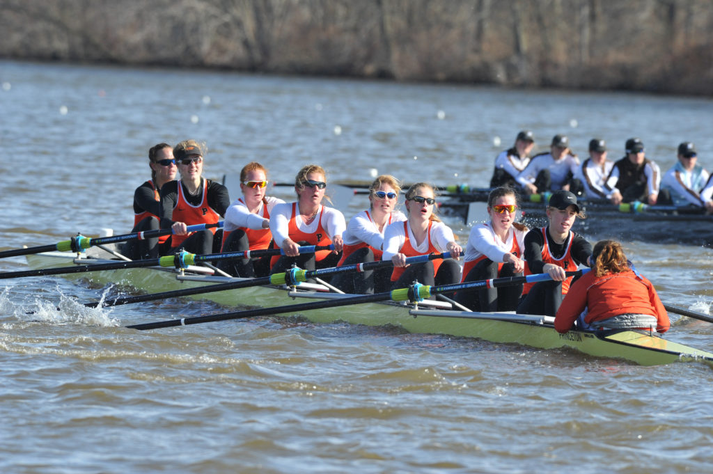 A group of people rowing a boat in the water