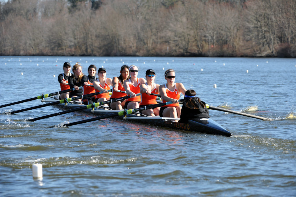 A group of people rowing a boat in the water