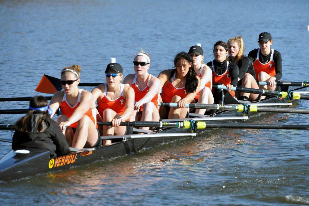 A group of people rowing a boat in the water