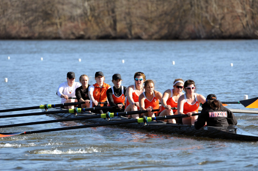 A group of people rowing a boat in a body of water