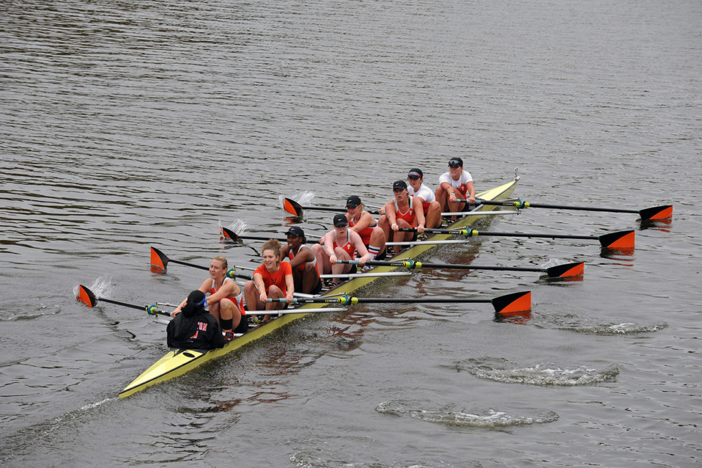 A group of people rowing a boat in the water