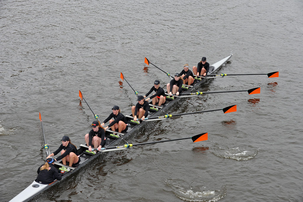 A group of people rowing a boat in the water