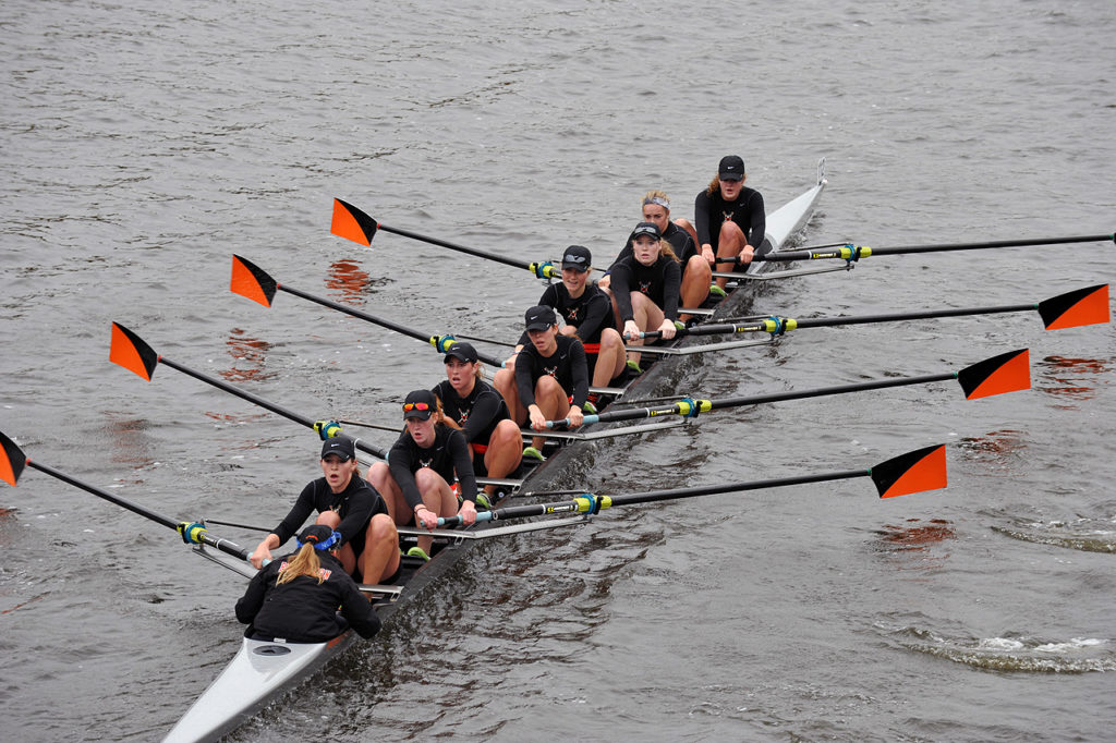 A group of people rowing a boat in the water