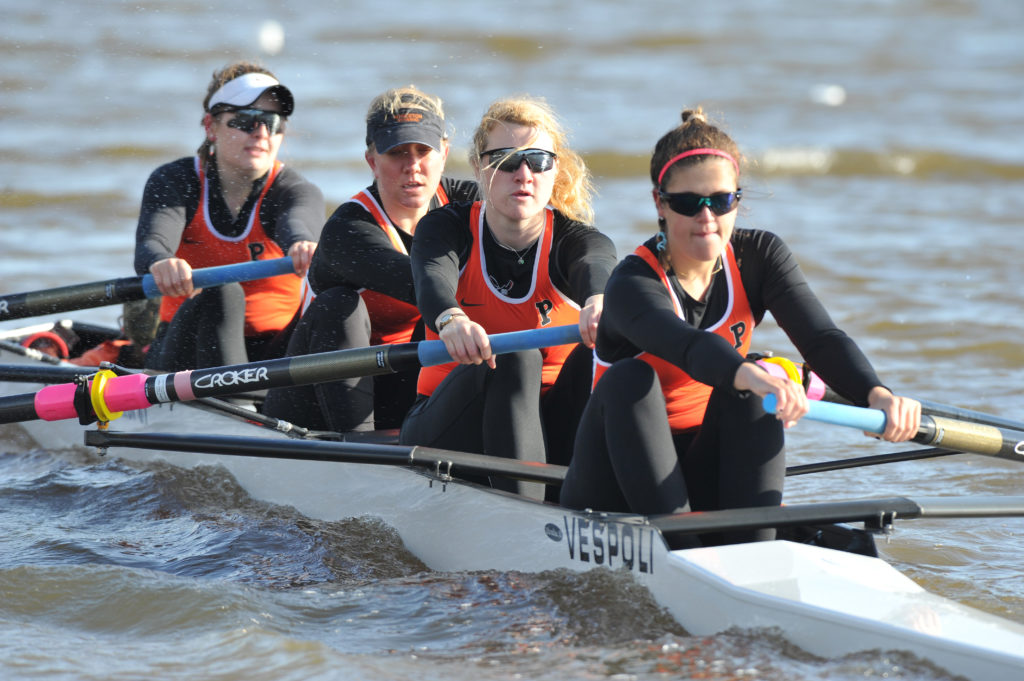 A group of people rowing a boat in the water