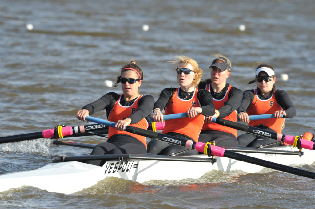 A group of people rowing a boat in a body of water