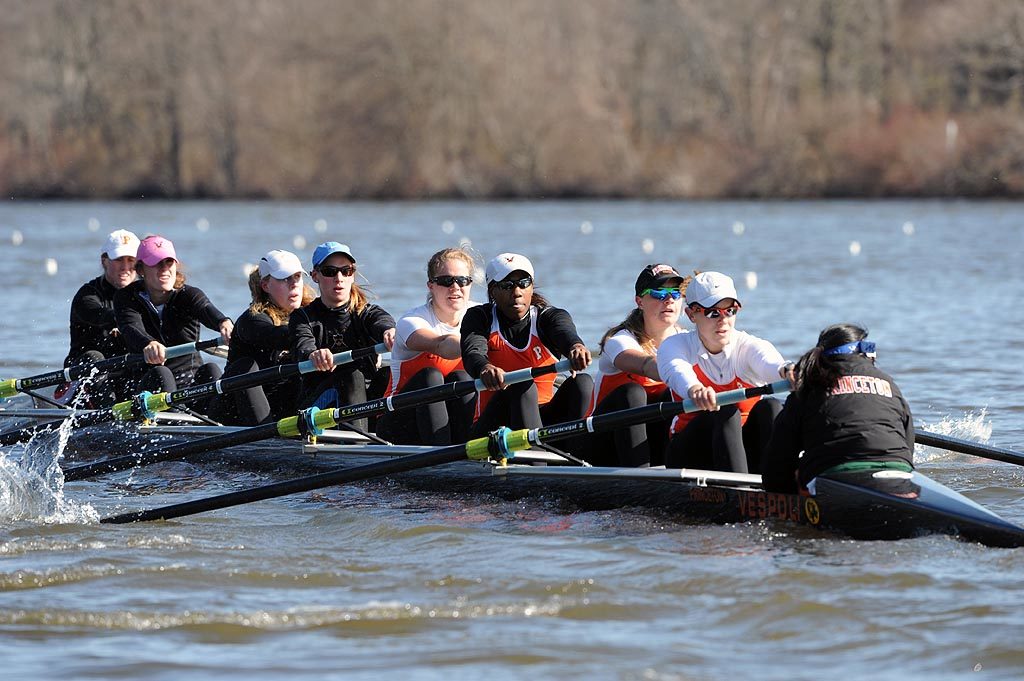 A group of people rowing a boat in a body of water