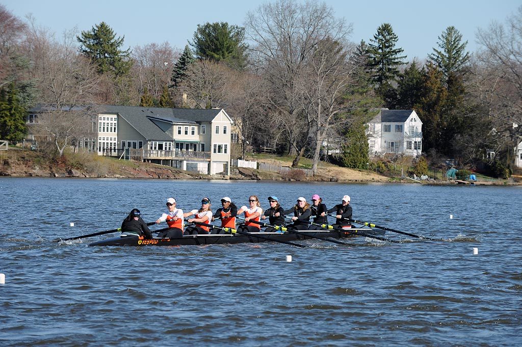 A group of people rowing a boat in the water