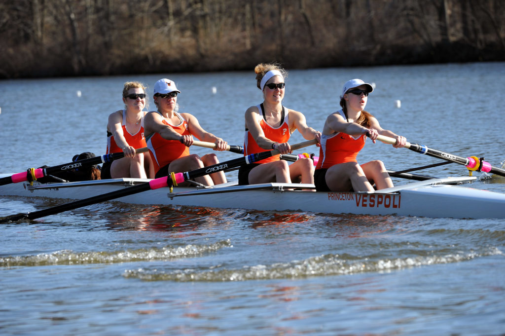 A group of people rowing a boat in the water