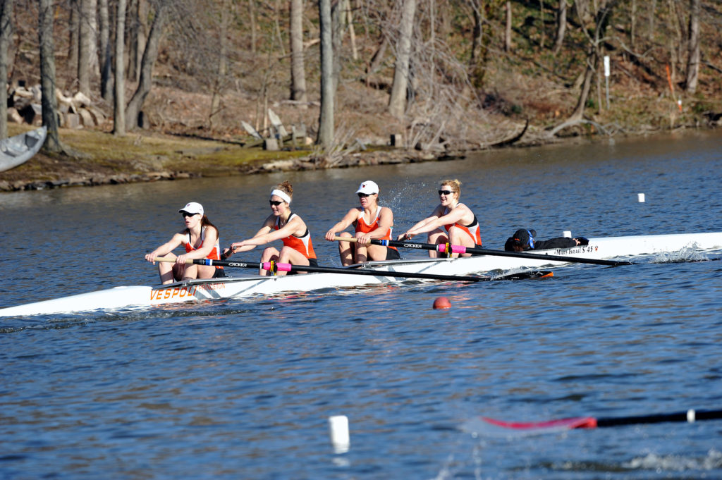 A group of people rowing a boat in the water