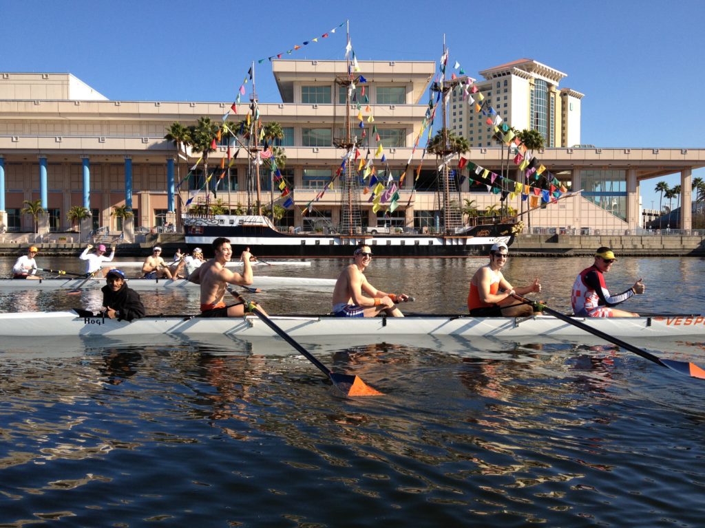 A group of people rowing a boat in the water