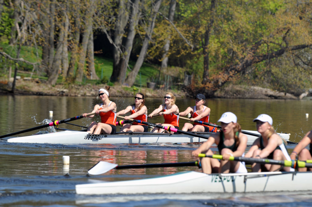 A group of people rowing a boat in the water