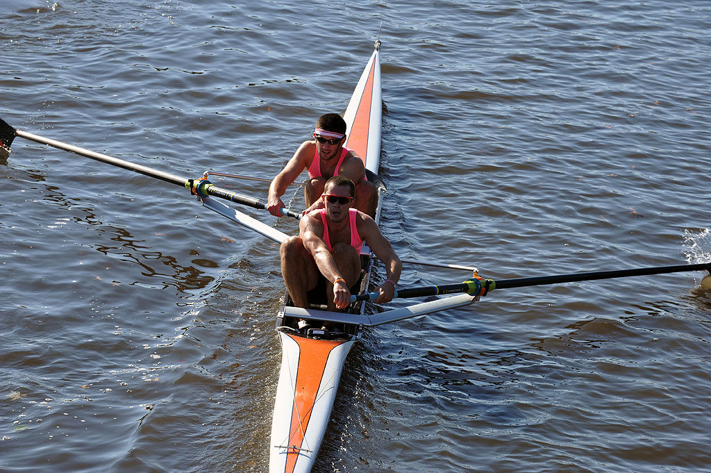 A group of people rowing a boat in a body of water