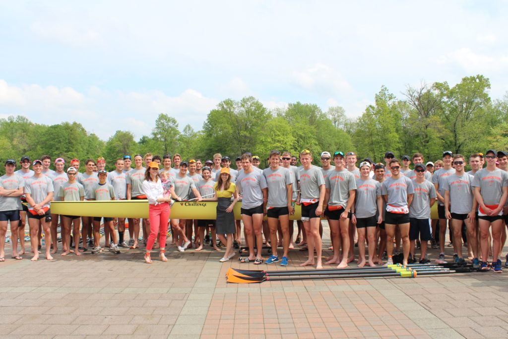 A group of people standing in front of a crowd posing for the camera