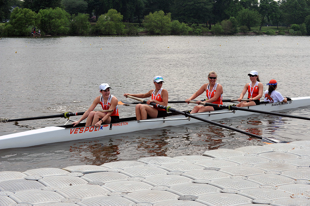 A group of people rowing a boat in a body of water