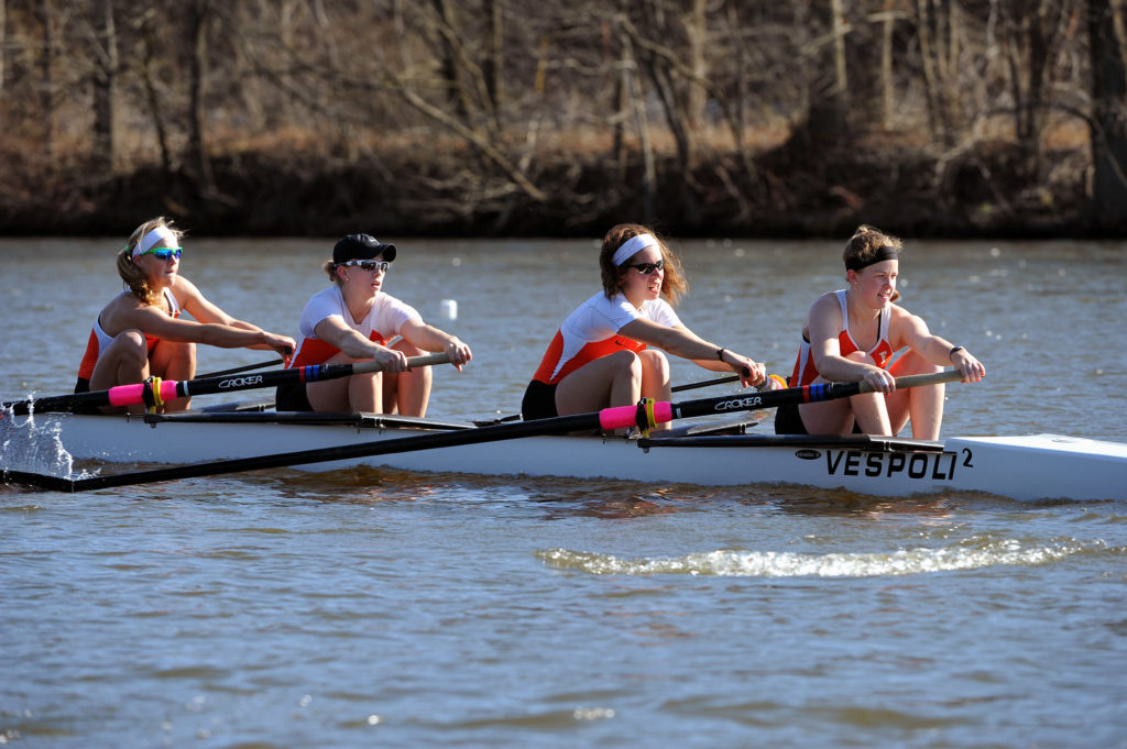 A group of people rowing a boat in the water