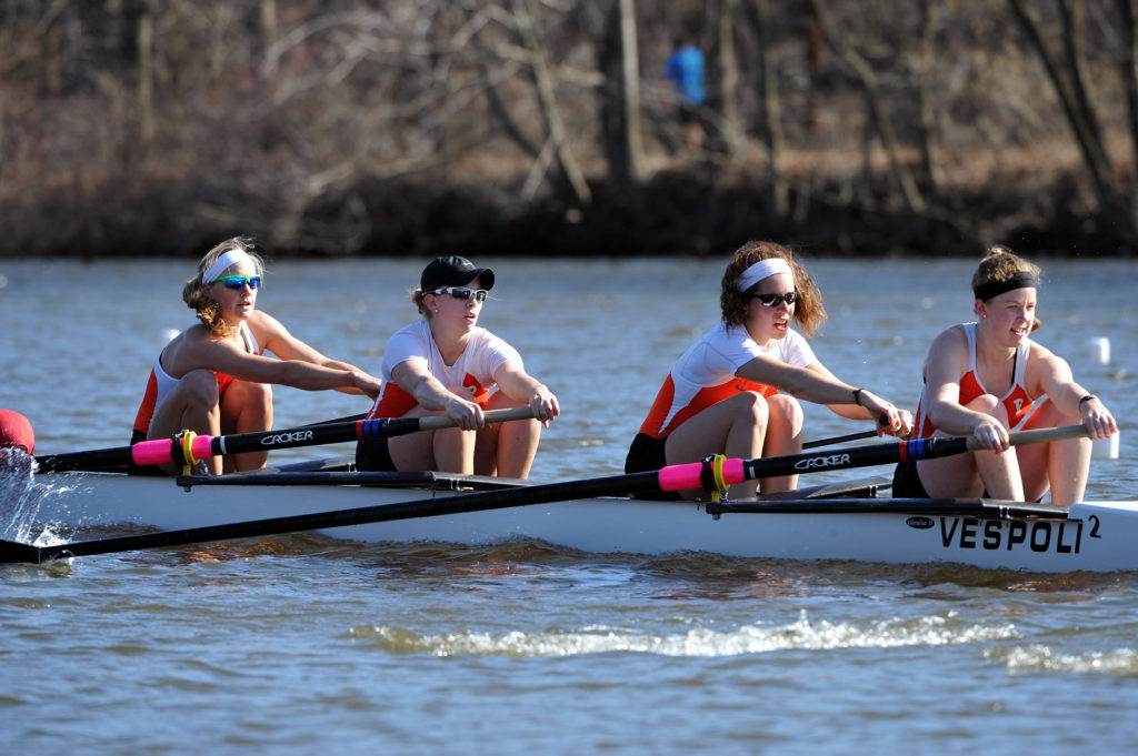 A group of people rowing a boat in the water