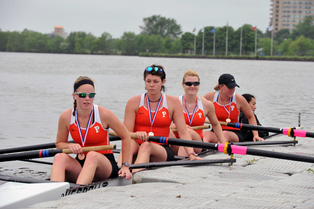 A group of people rowing a boat in the water