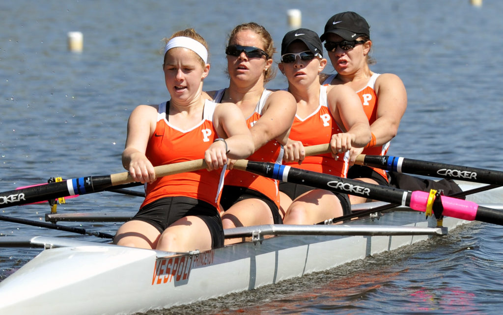 A group of people rowing a boat in the water