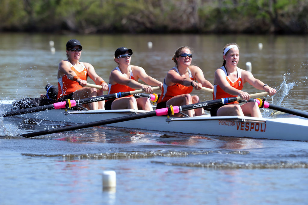 A group of people rowing a boat in a body of water