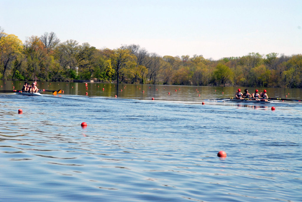 A group of people rowing a boat floating on a body of water