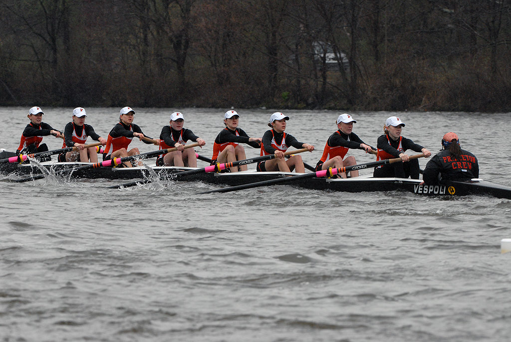 A group of people rowing a boat in the water