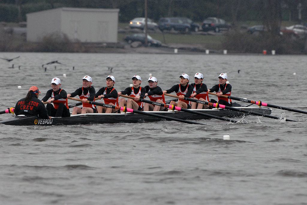 A group of people rowing a boat in the water