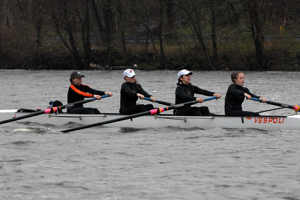 A group of people rowing a boat in a body of water