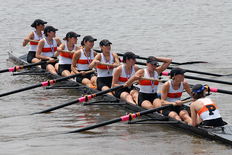 A group of people rowing a boat in a body of water