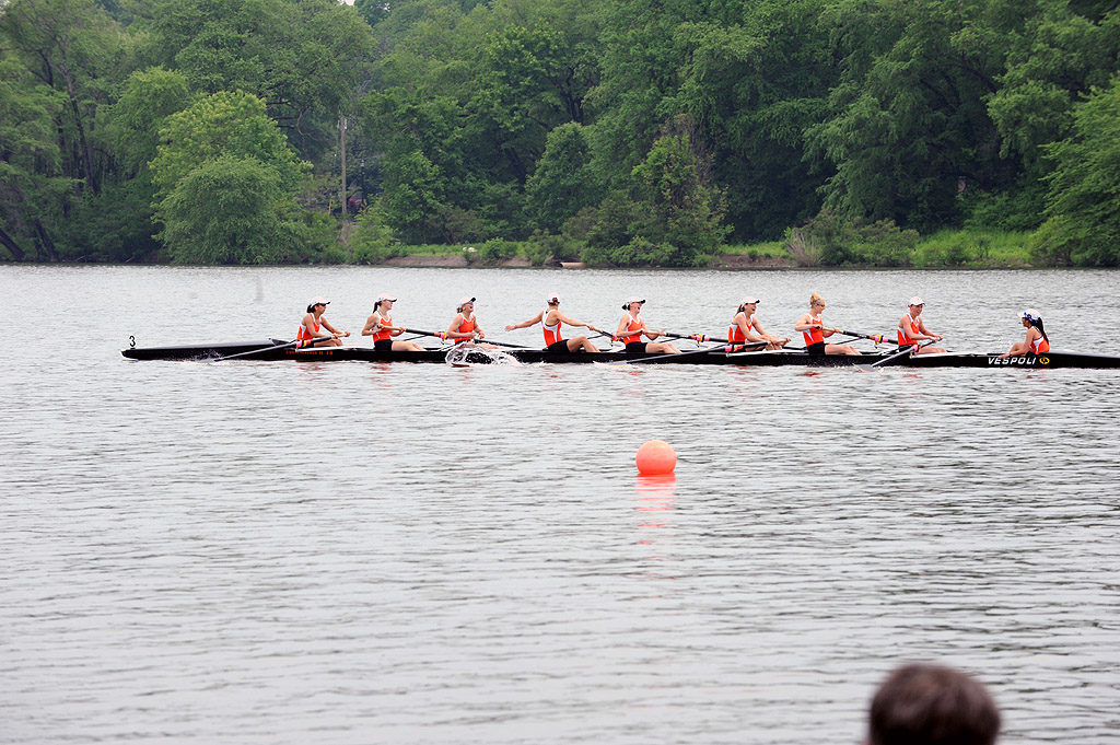 A group of people rowing a boat floating on a body of water