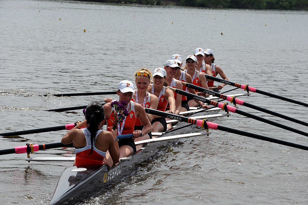 A group of people rowing a boat in a body of water