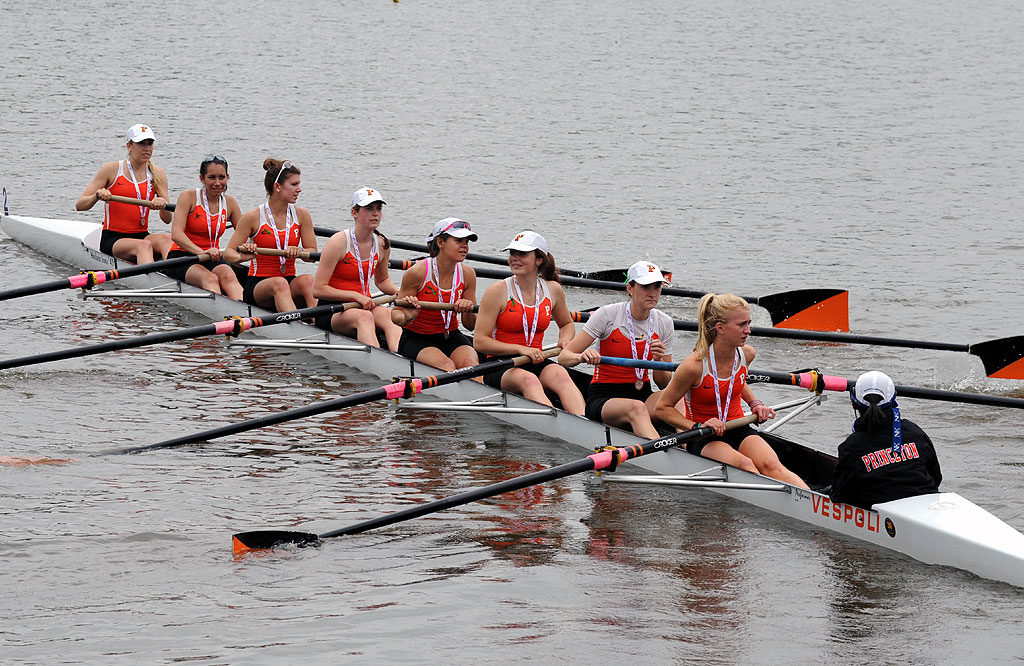 A group of people rowing a boat in the water