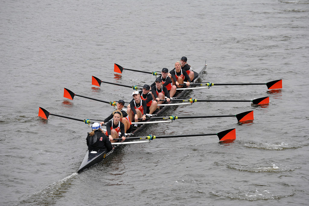 A group of people rowing a boat in the water