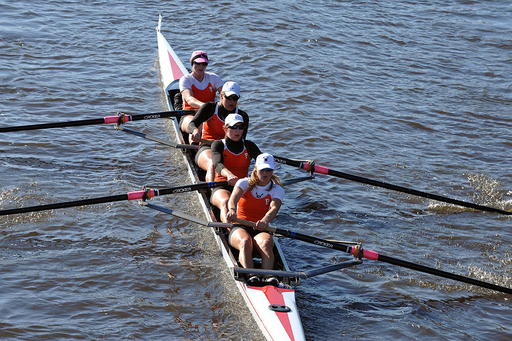 A group of people rowing a boat in a body of water