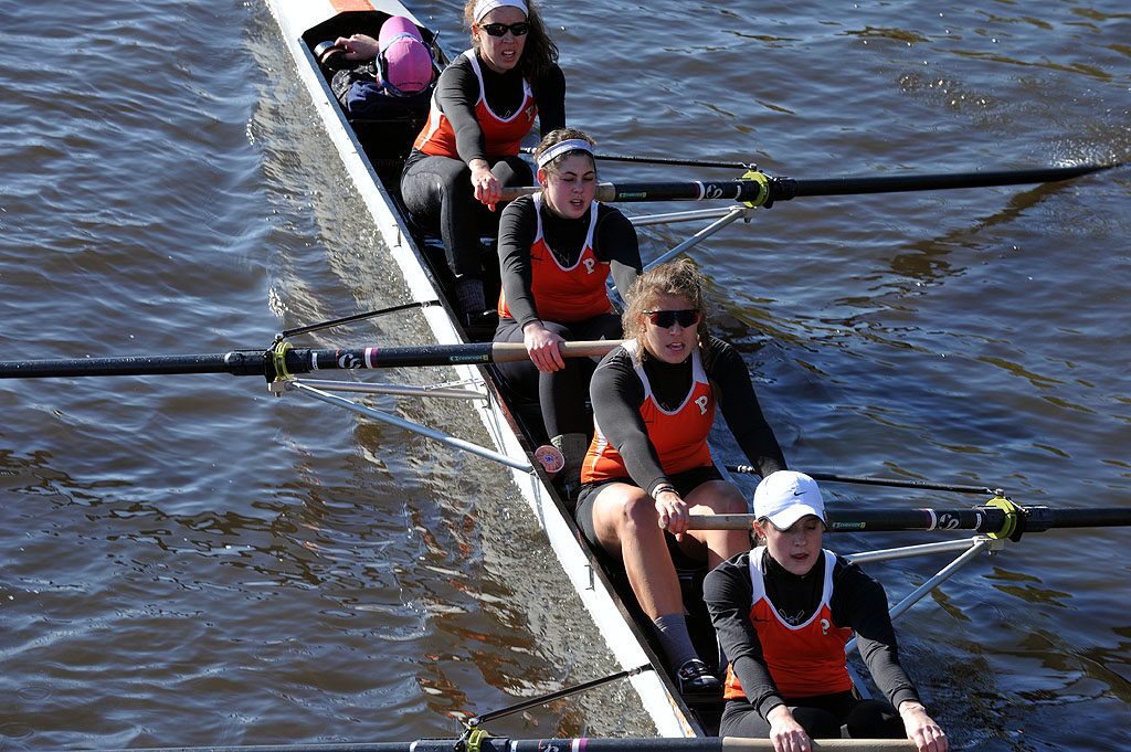 A group of people rowing a boat in a body of water