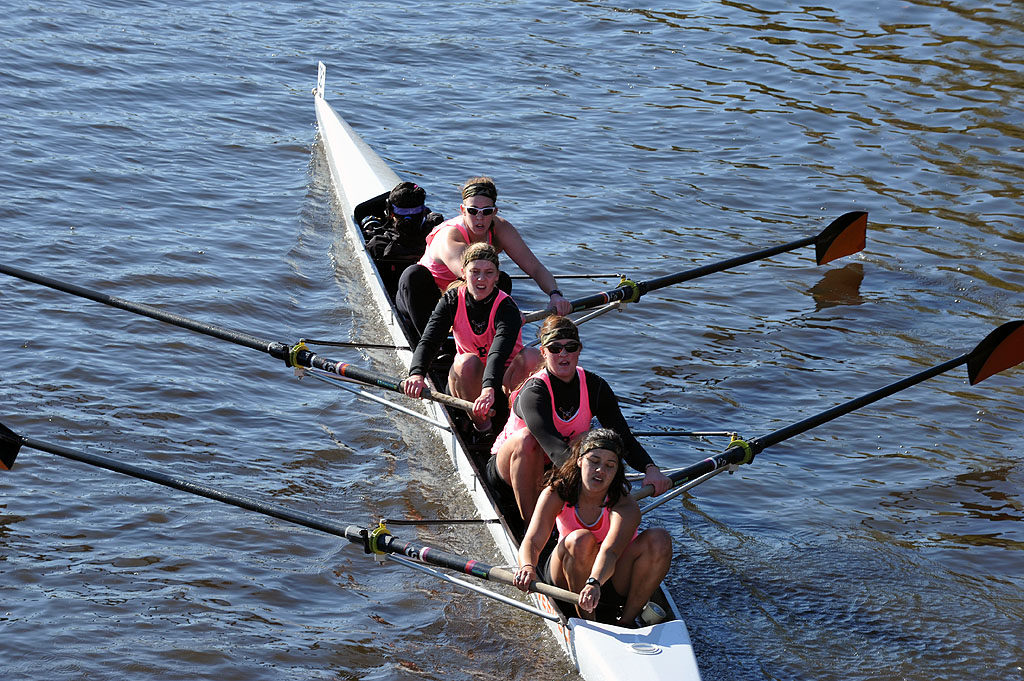 A group of people rowing a boat in a body of water