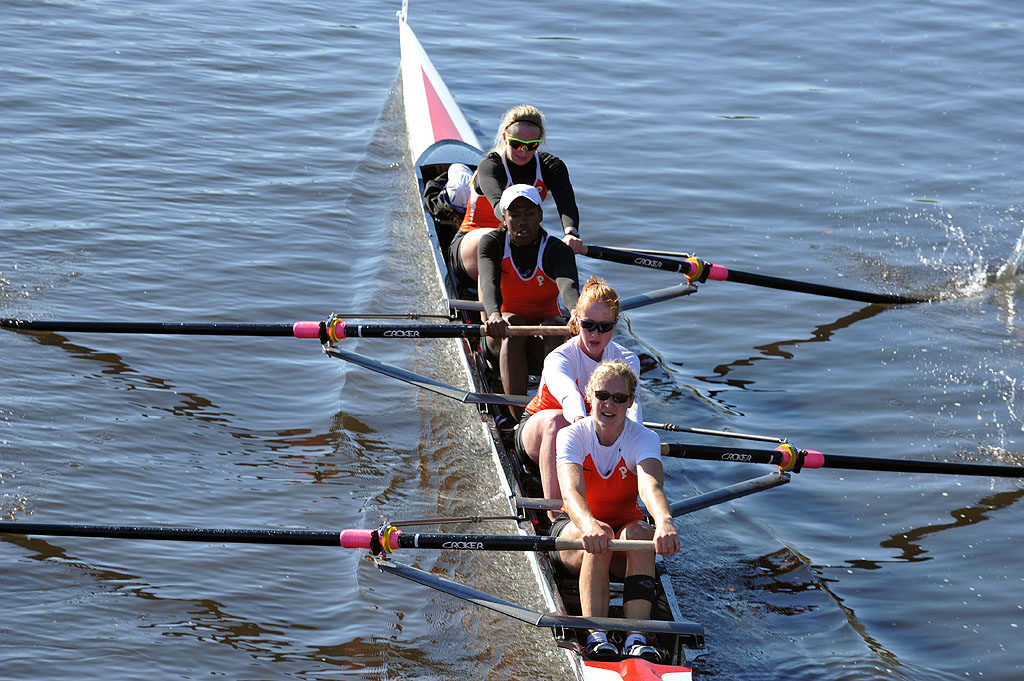 A group of people rowing a boat in the water