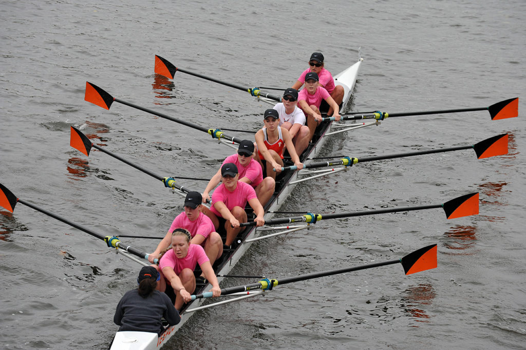 A group of people rowing a boat in the water