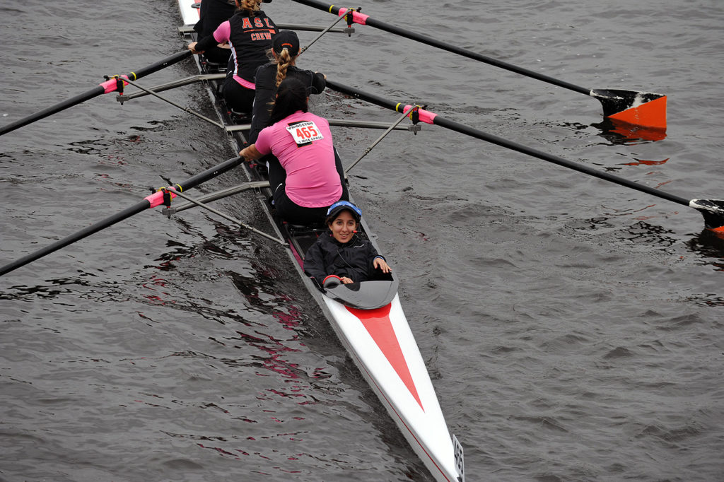 A group of people rowing a boat in the water