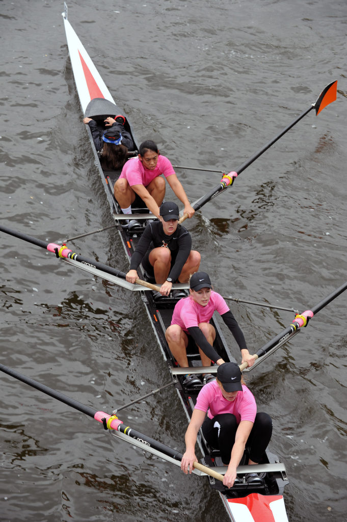 A group of people rowing a boat in the water