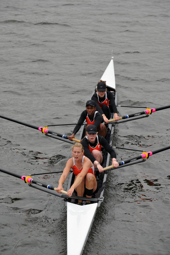 A group of people rowing a boat in the water