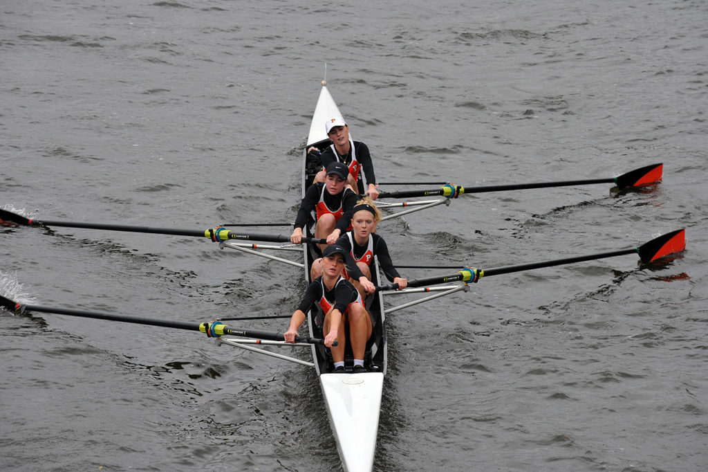 A group of people rowing a boat in the water