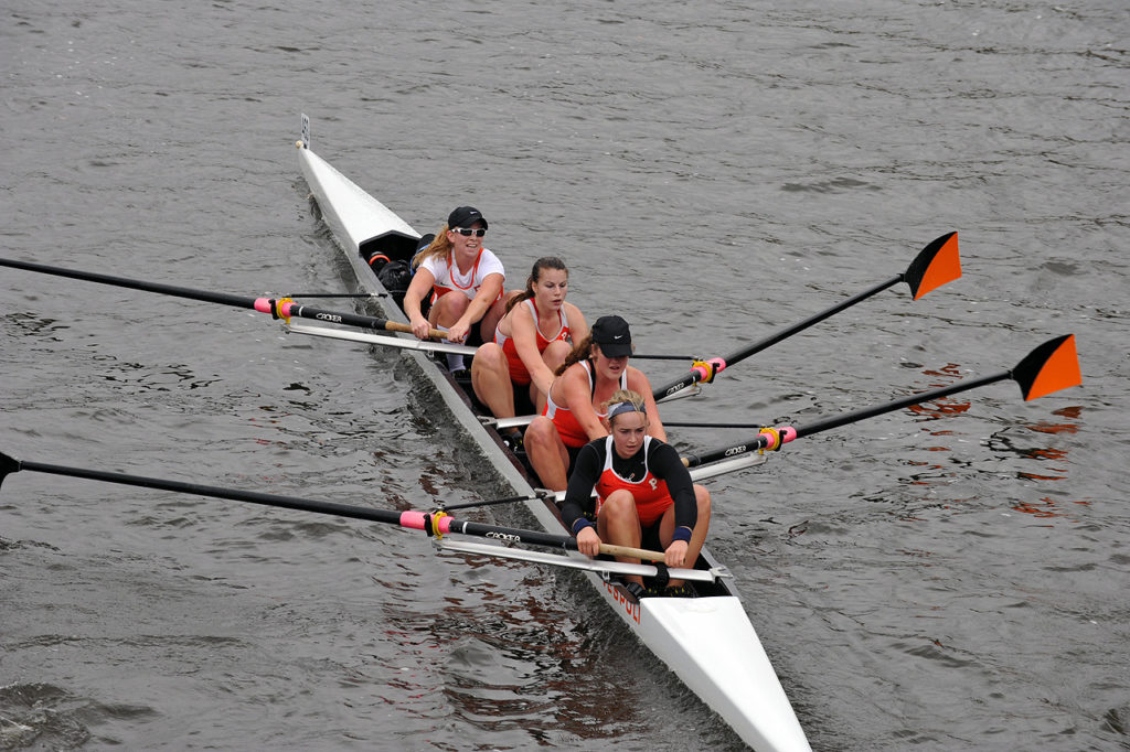 A group of people rowing a boat in the water