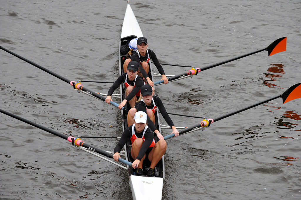 A group of people rowing a boat in the water