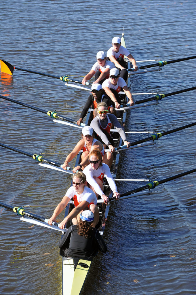 A group of people rowing a boat in a body of water