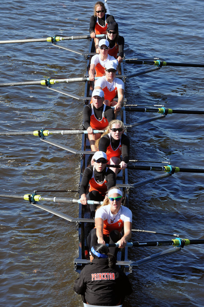 A group of people rowing a boat in the water