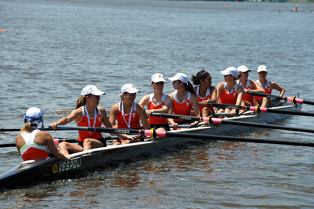 A group of people rowing a boat in a body of water