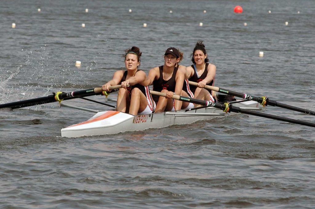 A group of people rowing a boat in a body of water