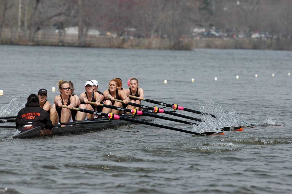 A group of people rowing a boat in the water