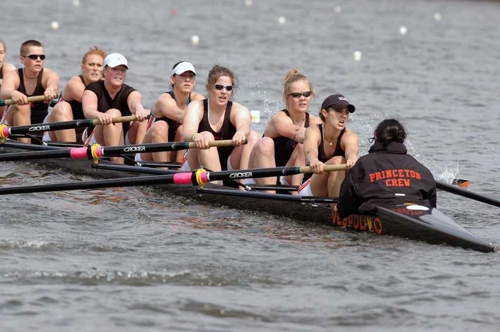 A group of people rowing a boat in a body of water