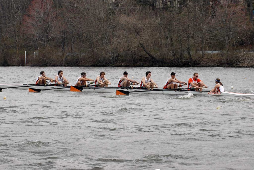 A group of people rowing a boat in a body of water